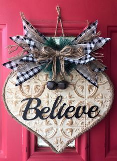 a heart shaped door hanger that says believe