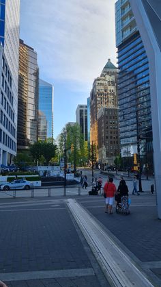 three people sitting on benches in the middle of a city square with tall buildings behind them