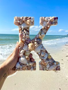 the letter k is made out of seashells on the beach