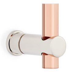 an image of a rose gold and white door handle on a wall mounted toilet paper dispenser