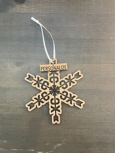 a personalized wooden ornament hanging from a string on top of a table