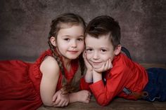 two young children laying on the floor with their arms around each other