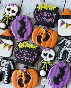 decorated cookies are arranged in the shape of pumpkins and skeletons with words that read, a baby is brewing