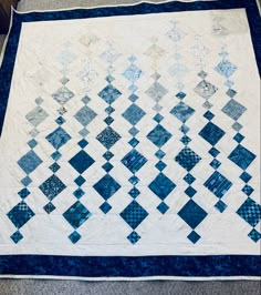 a blue and white quilt on the floor