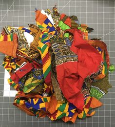 a pile of multicolored fabric sitting on top of a cutting board