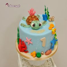 a blue cake decorated with sea animals and marine life on top of a white table