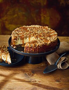 a cheesecake with caramel drizzled on top and two slices cut out