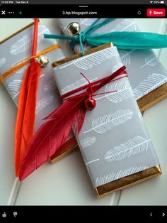 three wrapped gifts with feathers tied to them