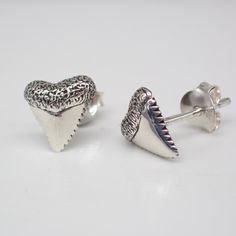 These recycled sterling silver stud earrings are meticulously crafted from recycled sterling silver, embodying our commitment to environmental consciousness without compromising style. They measure 9 mm long and come with a sterling silver back. Shark teeth hold symbolic significance representing strength, resilience, and adaptability. These razor-sharp artifacts are often associated with the primal power of sharks, creatures known for their predatory prowess and survival instincts. In various c Sterling Silver White Gold Plug Earrings For Gift, White Gold Sterling Silver Plug Earrings As Gift, Hypoallergenic White Gold Plug Earrings In Sterling Silver, Sterling Silver White Gold Plug Earrings, Silver Shark, Environmental Consciousness, Survival Instinct, Shark Teeth, Recycled Sterling Silver