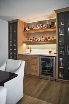 a kitchen with wooden floors and shelves filled with bottles