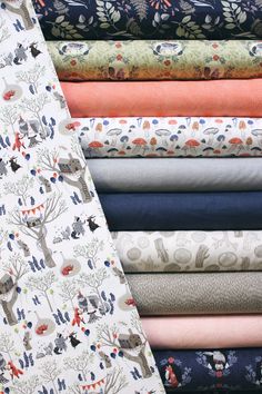 an assortment of fabrics are stacked on top of each other in different colors and patterns