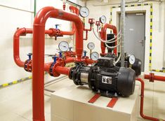 pipes and valves in a room with tiled walls, flooring and white tile floors