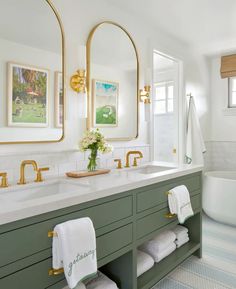 a bathroom with green cabinets and gold fixtures