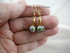 Brown with pink green flower 12 mm round Cloisonne and oblong gold bead accent dangle earring pair E Gold Beaded Earrings With French Hook As Gift, Gold Beaded Flower-shaped Earrings, Gold Jewelry With French Hook And Round Beads, Gold Flower-shaped Beaded Earrings, Nickel-free Green Round Flower Earrings, Green French Hook Earrings, Gold Round Beads Flower Earrings As Gift, Gold Flower Earrings With Round Beads For Gift, Green Flower Earrings With Round Beads