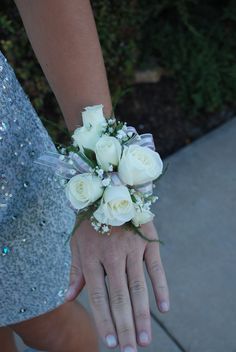 a person holding a bouquet of white roses in their left hand and wearing a sequined dress