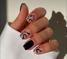 a woman's hand with black and white nail polish