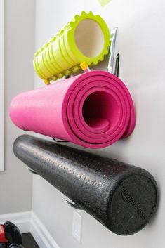 there is a wall mounted exercise mat and dumbbells on the wall next to each other