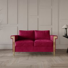 a living room with a pink couch and lamp on the side table next to it