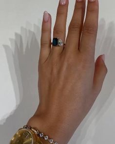 a woman's hand with a ring on it and a watch in the other hand