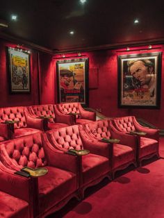 an empty movie theater with red seats and posters on the wall behind them in front of two framed movies