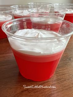 red cups filled with yogurt sitting on top of a wooden table