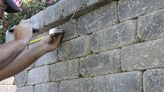 a man is painting the side of a brick wall