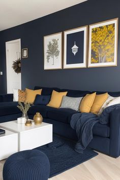 a living room with blue couches, yellow pillows and pictures on the wall above them