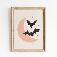 two bats flying over the moon on a white wall