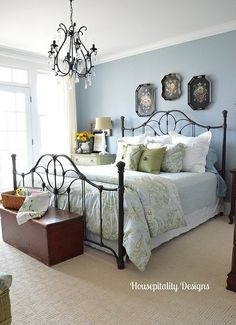 a bed room with a neatly made bed and a chandelier