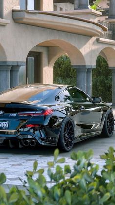 a black sports car parked in front of a building