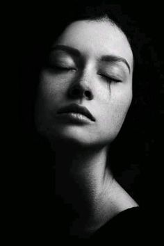 black and white photograph of a woman with her eyes closed in the dark, sleeping