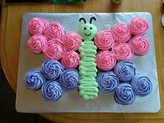 cupcakes in the shape of a butterfly on a plate with pink and blue frosting