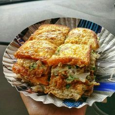 a person holding up a paper plate with some food on it