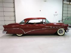 an old red car parked in a garage