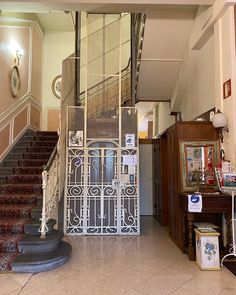 an entrance to a building with wrought iron gates and stairs leading up to the second floor