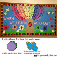 a bulletin board with colorful paper flowers and butterflies in the shape of a tree that says when we learn, we grow