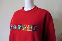 Beautiful Vintage sweatshirt from the French fashion brand Naf Naf. Cozy fabric, fleeced inside. Classic sweatshirt cut. Crew neck, fine ribbed cuffs and waistband. Multicolor Naf Naf embroidery on the front. BRAND: Naf Naf ERA: 1990s COLOR: Red, multicolor FABRIC: 59% polyester, 41% cotton SIZE: No size tag, fits best size M-L (or S for an oversized fit) - please check the measurements below for reference MEASUREMENTS: Pit to pit 56cm, total length 68cm CONDITION: Very good Vintage condition Red Sweatshirt With Embroidered Logo For Fall, Red Embroidered Text Sweatshirt For Fall, Vintage Embroidered Text Sweatshirt For Winter, Red Sweatshirt With Embroidered Text For Streetwear, Vintage Winter Sweatshirt With Embroidered Text, 90s Red Sweatshirt For Winter, Red Winter Sweatshirt With Embroidered Text, 90s Red Letter Print Sweatshirt, 90s Retro Sweatshirts Nike