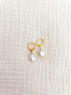 1 pair of freshwater pearl earrings on gold plated brass huggies! Pearls are small and between 0.5"-0.75" Please note: pearls may not be perfectly round/flat For best use do not wear in water or to bed :) Gold Hypoallergenic Pearl Huggie Earrings, Pearl Charm Huggie Earrings, Gold Adjustable Small Hoop Pearl Earrings, Gold Huggie Pearl Drop Earrings, Hypoallergenic Pearl Huggie Earrings, Hypoallergenic Huggie Pearl Earrings, Pearl Huggie Earrings With Pearl Charm, Flat Pearl Earrings, Freshwater Pearl Earrings