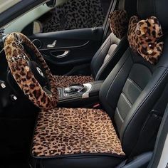 the interior of a car with leopard print seat covers and steering wheel cover on it