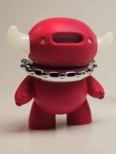 a red toy with horns and chains around its neck