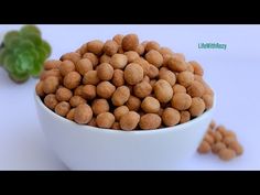 a white bowl filled with chickpeas next to some lettuce on a table