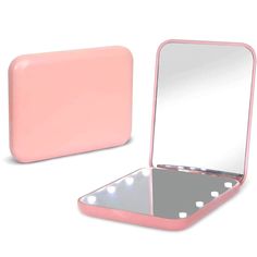 a pink vanity mirror with light up lights on the sides and an open case for it