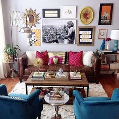 a living room with couches, chairs and pictures on the wall above them in various colors