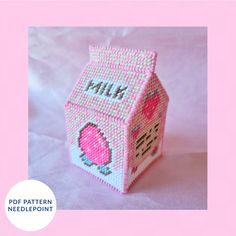 a small pink toy house made out of plastic beads with the word milk printed on it