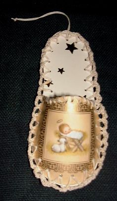 an ornament with a baby jesus on it's back and stars hanging from the top