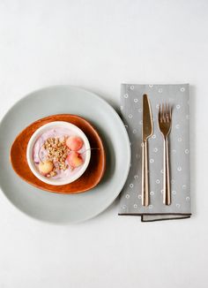 a white plate topped with food next to a fork and knife on top of a napkin