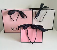 two pink and black bags with ribbons tied to the handles, one is for stac