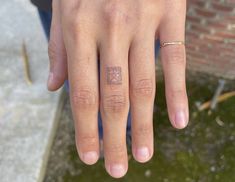 a person's hand with a small tattoo on it