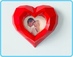 a red heart shaped photo frame with a man and woman in it