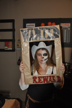 a woman holding up a cardboard sign with the word wanted in it's center